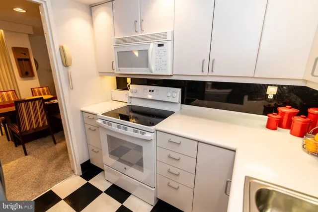 a kitchen with a refrigerator sink and cabinets