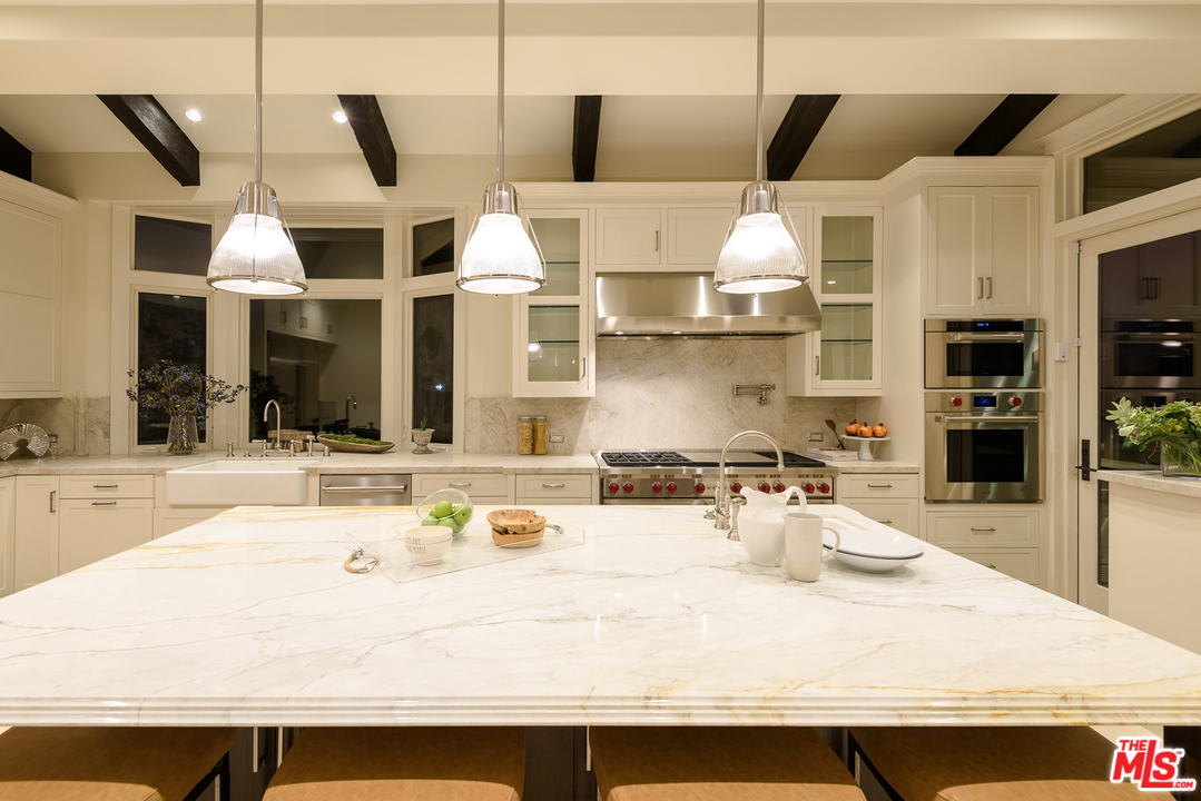 2175 Summitridge Drive Beverly Hills, CA 90210 - Photo 17 of 51 a kitchen with stainless steel appliances kitchen island granite countertop a sink and cabinets