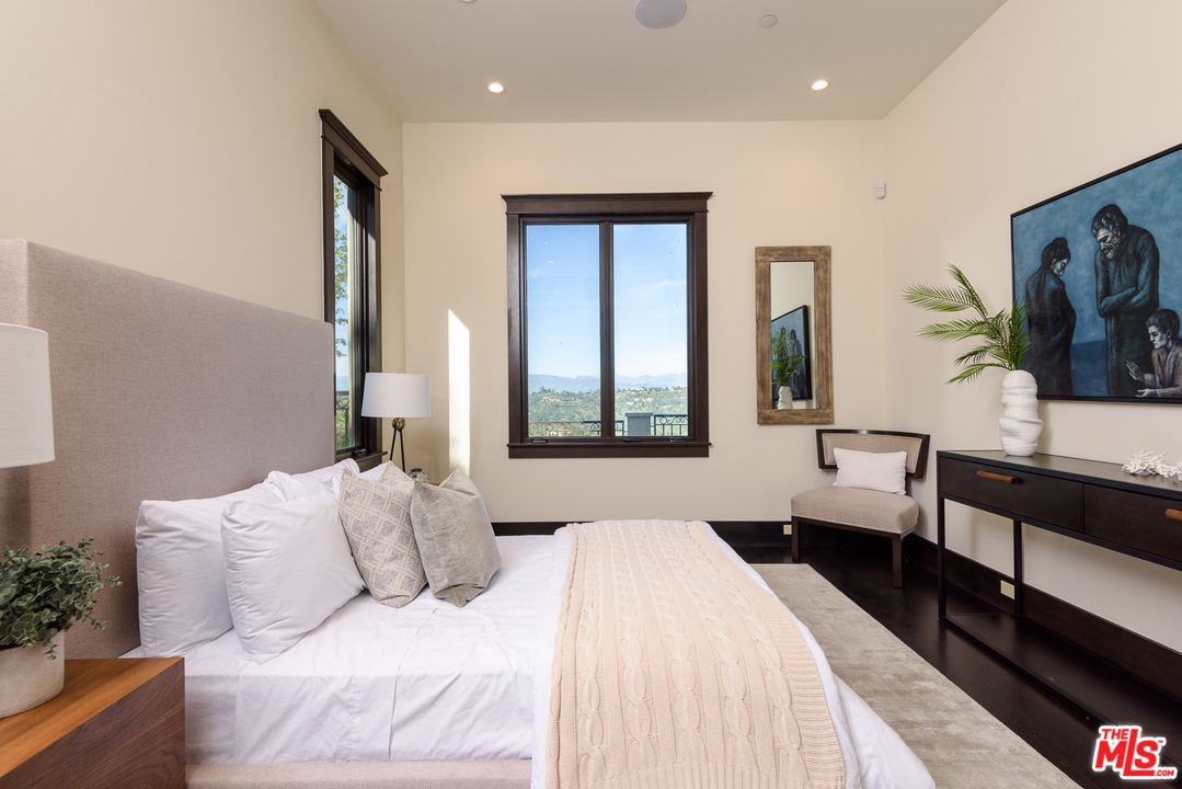 2175 Summitridge Drive Beverly Hills, CA 90210 - Photo 34 of 51 a bedroom with a large bed and a flat tv screen on dresser