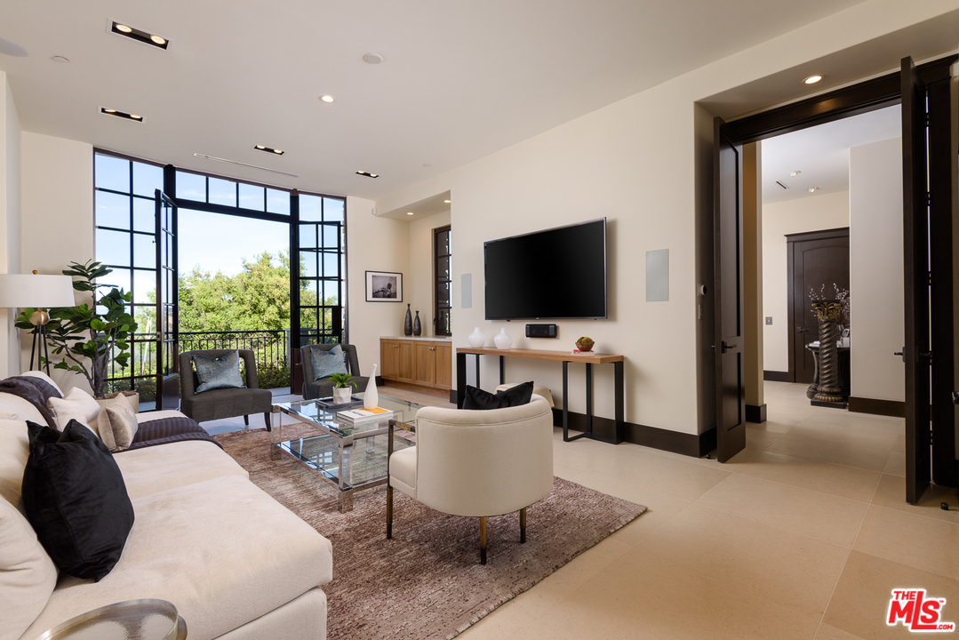 2175 Summitridge Drive Beverly Hills, CA 90210 - Photo 7 of 51 a living room with furniture a flat screen tv and floor to ceiling window