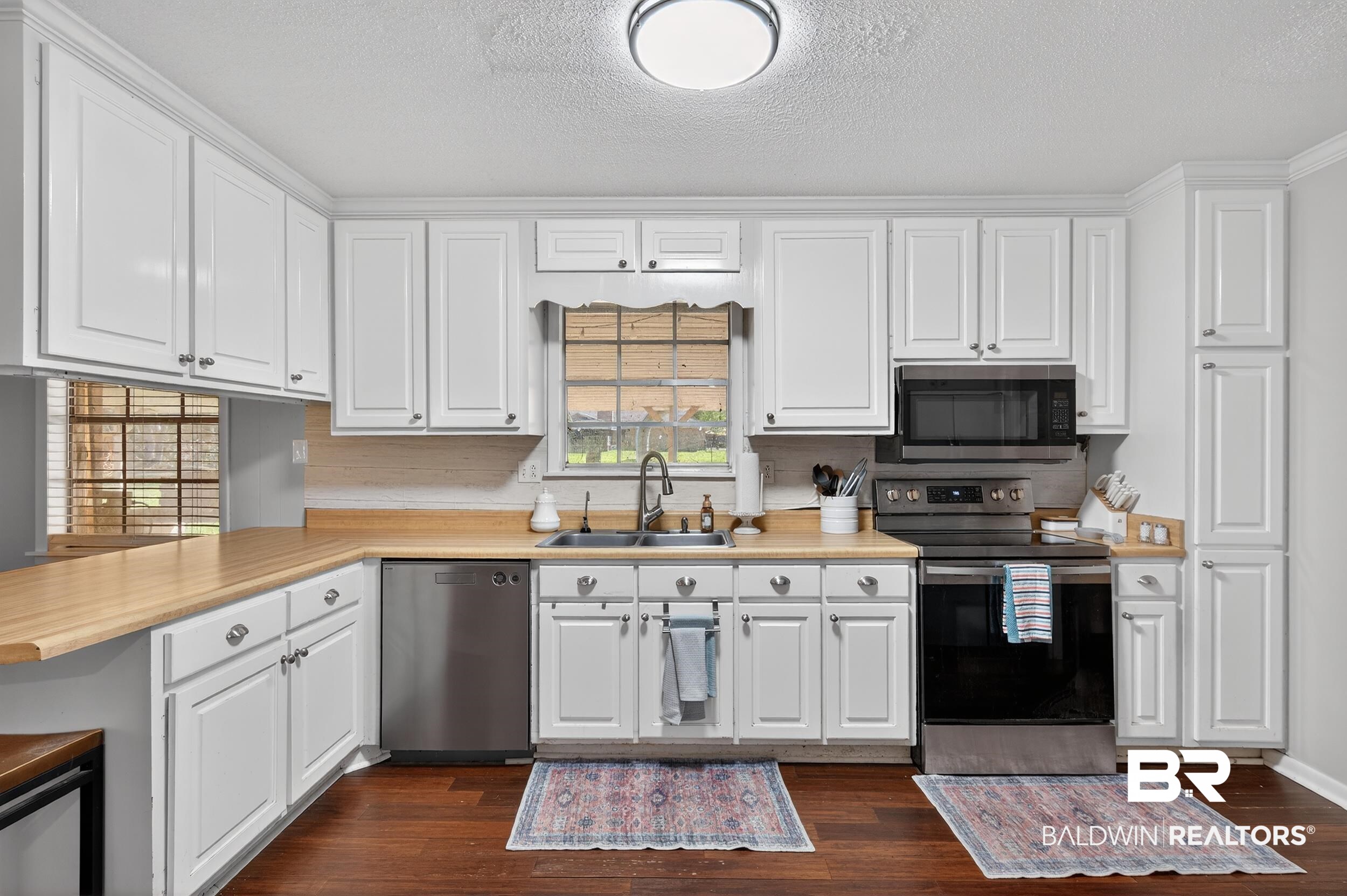 46006 Pecan Lane Bay Minette, AL 36507 - Photo 13 of 40 Kitchen featuring light countertops, stainless steel appliances, white cabinets, and a textured ceiling