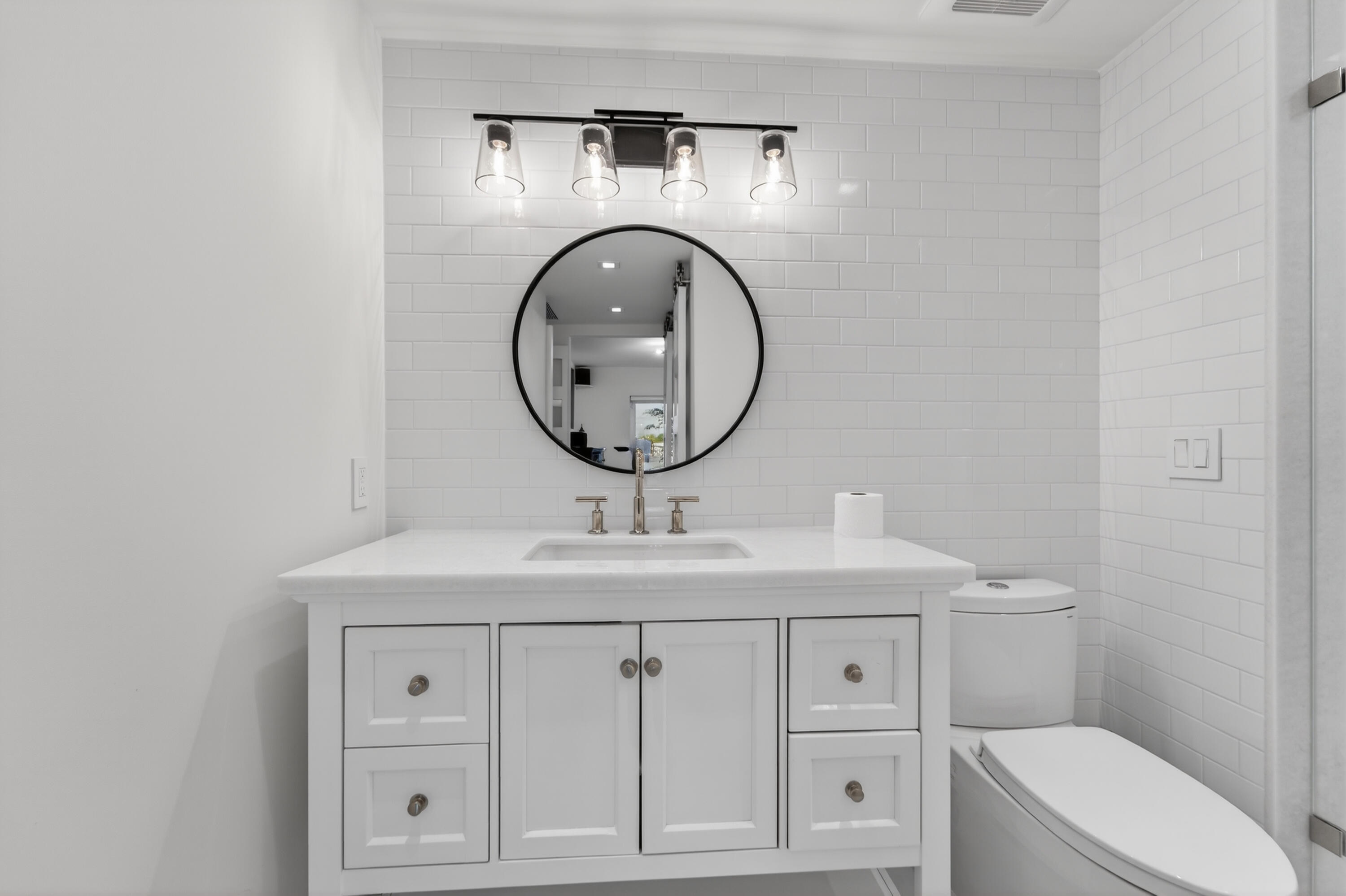 725 Hummingbird Way, Unit 103 North Palm Beach, FL 33408 - Photo 17 of 52 a bathroom with a sink a toilet and a mirror