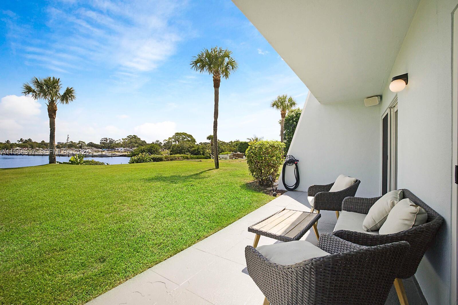725 Hummingbird Way, Unit 103 North Palm Beach, FL 33408 - Photo 2 of 52 a view of a table and chairs in the patio
