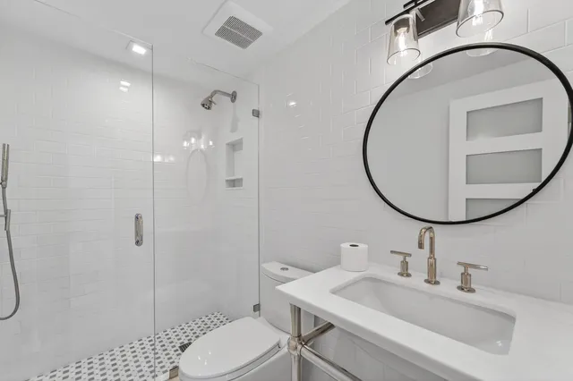 a kitchen with stainless steel appliances kitchen island granite countertop a stove a sink a refrigerator a stove a dining table and chairs with wooden floor