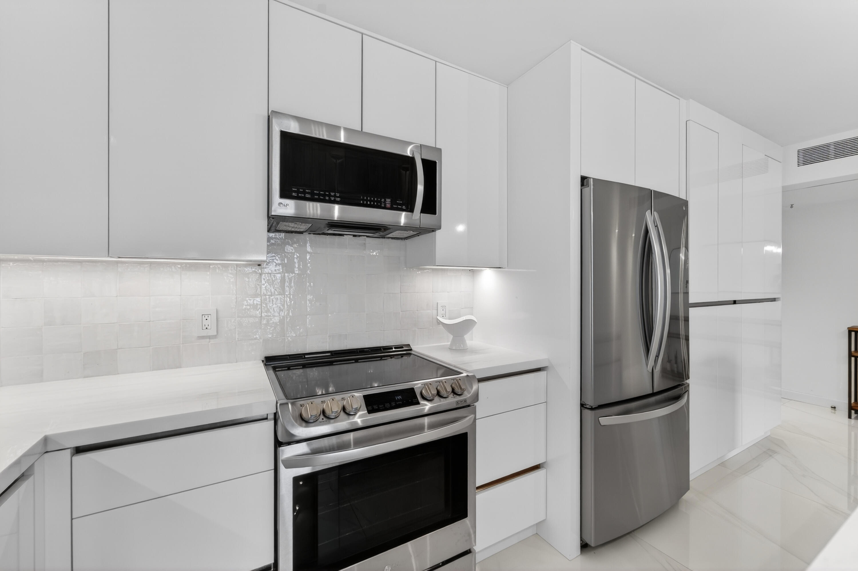 725 Hummingbird Way, Unit 103 North Palm Beach, FL 33408 - Photo 26 of 52 a kitchen with stainless steel appliances a refrigerator stove and microwave