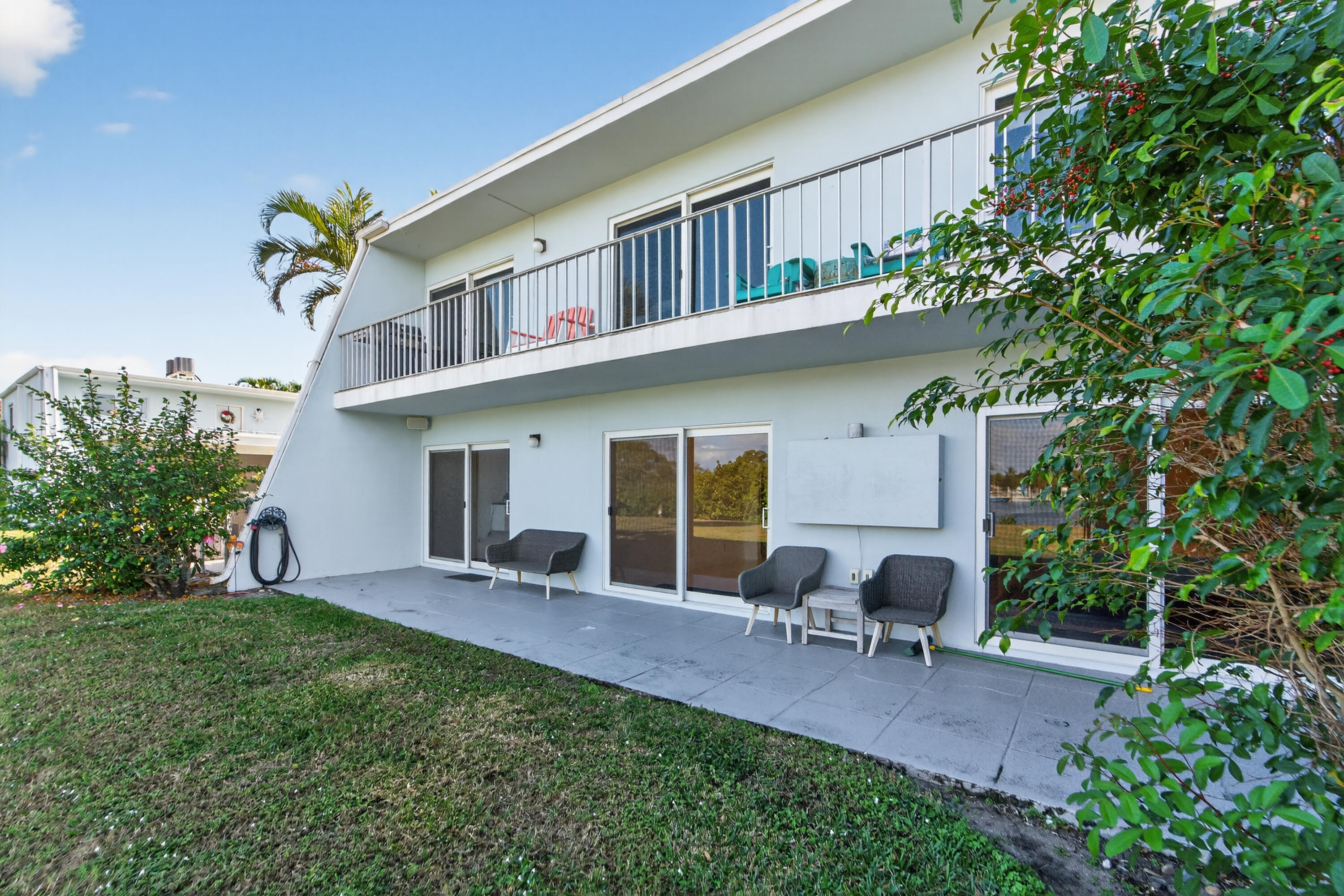 725 Hummingbird Way, Unit 103 North Palm Beach, FL 33408 - Photo 37 of 52 a view of a house with a yard and sitting area