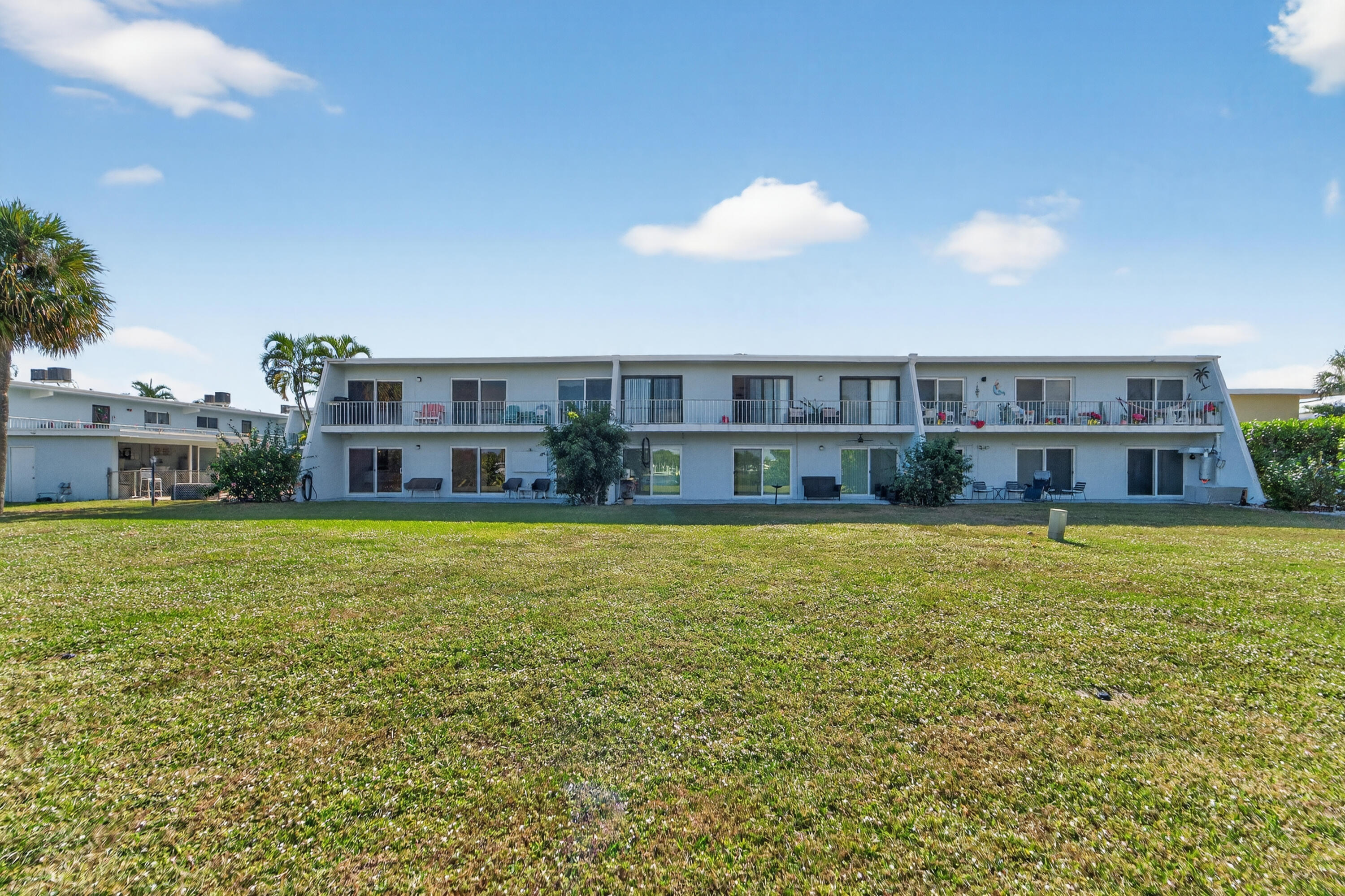 725 Hummingbird Way, Unit 103 North Palm Beach, FL 33408 - Photo 38 of 52 a view of a house with a yard and sitting area