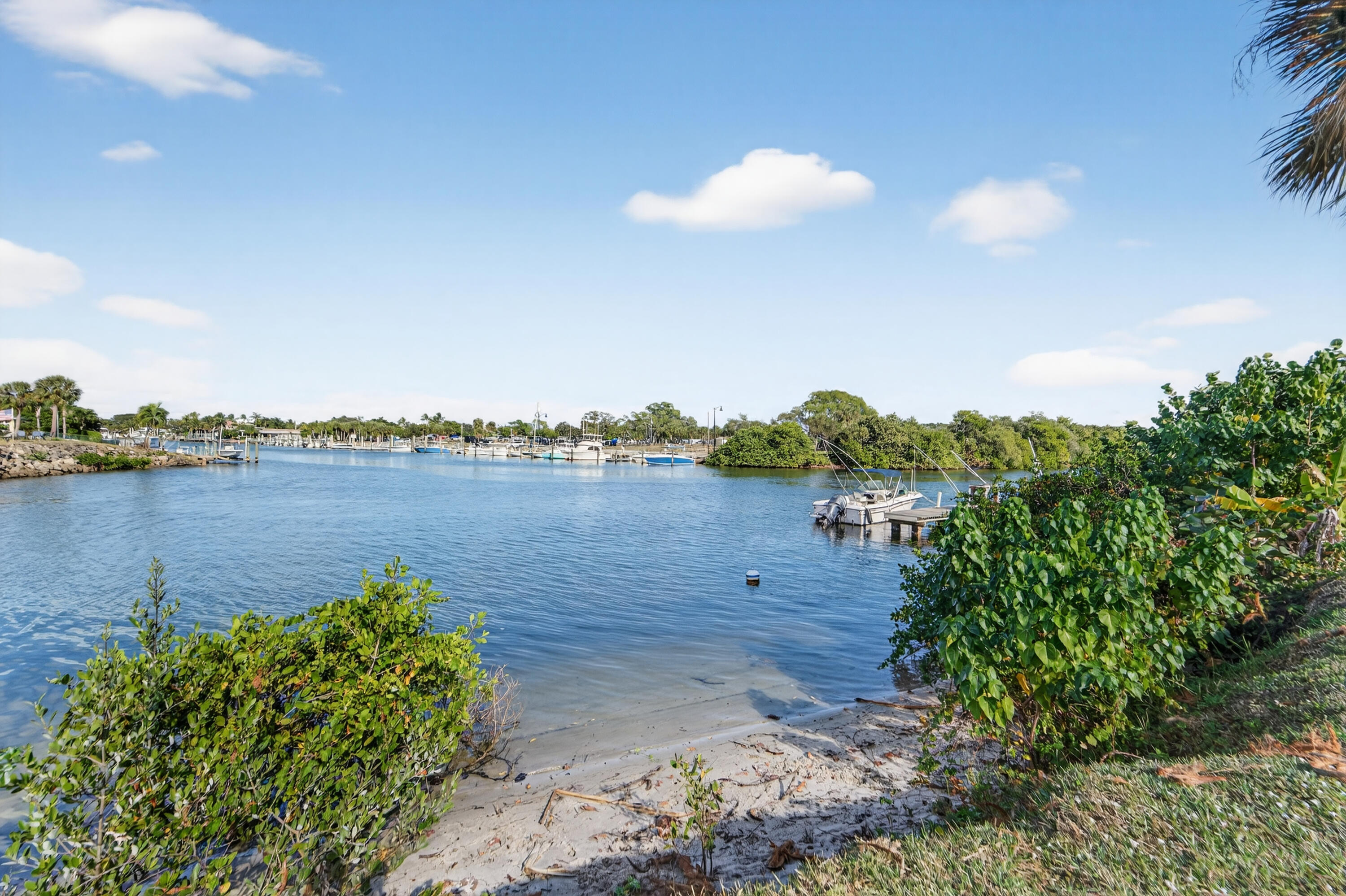 725 Hummingbird Way, Unit 103 North Palm Beach, FL 33408 - Photo 39 of 52 a view of a lake with couches in front of house