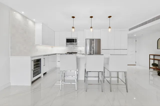a kitchen with kitchen island white cabinets and stainless steel appliances
