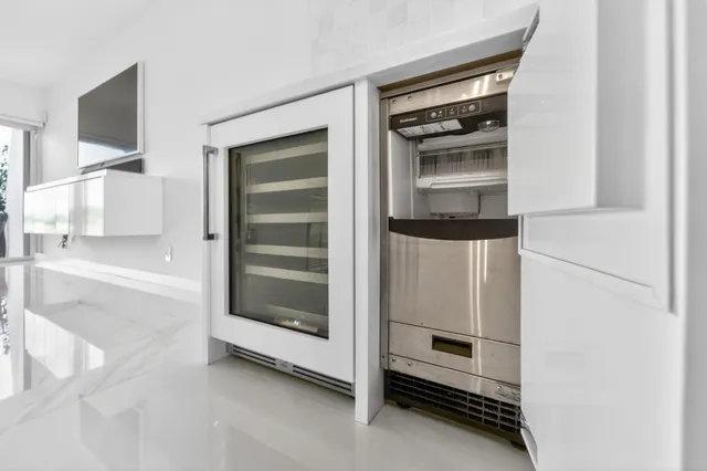 a view of an empty room and kitchen
