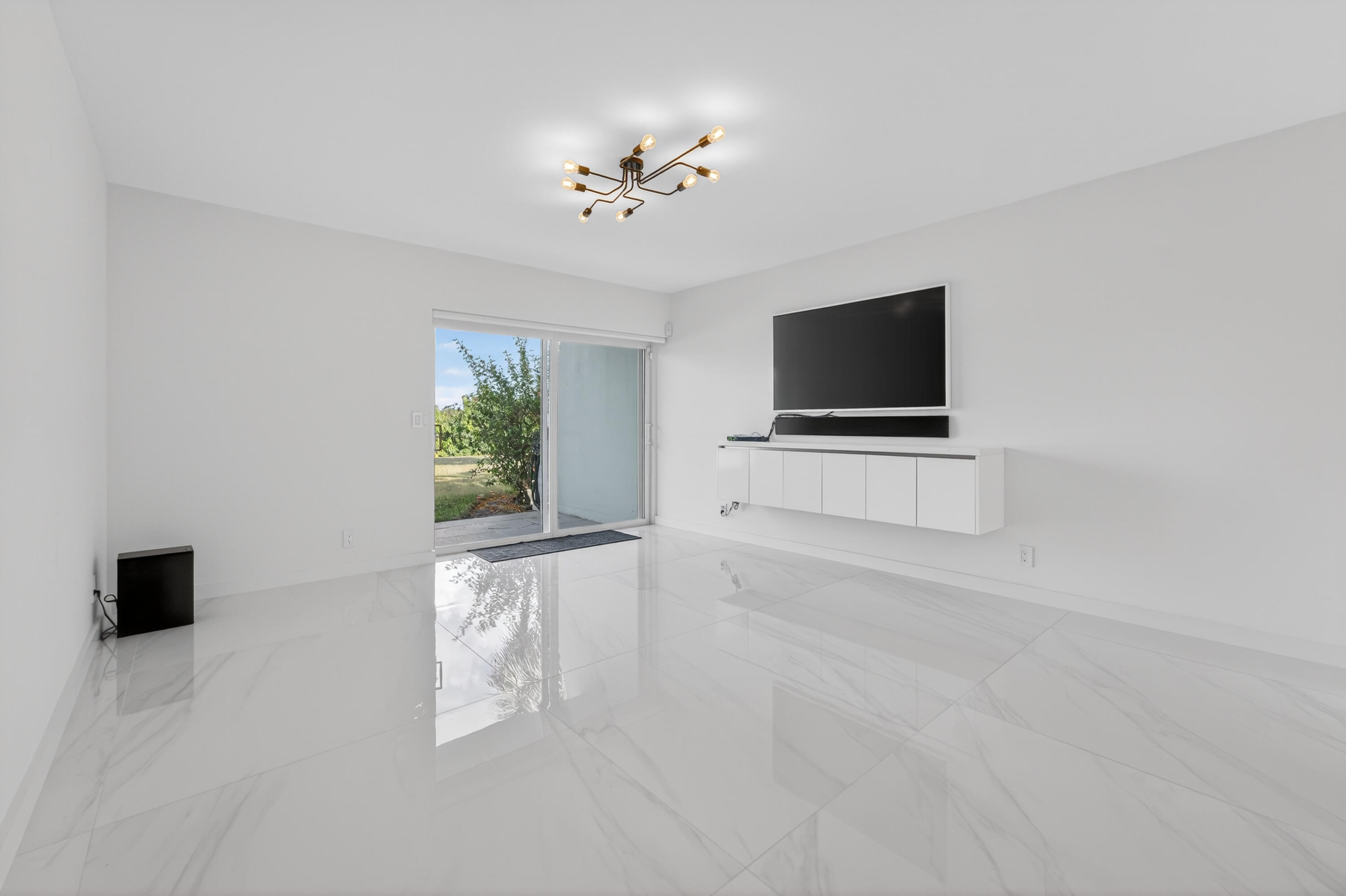 725 Hummingbird Way, Unit 103 North Palm Beach, FL 33408 - Photo 7 of 52 a living room with furniture and a flat screen tv
