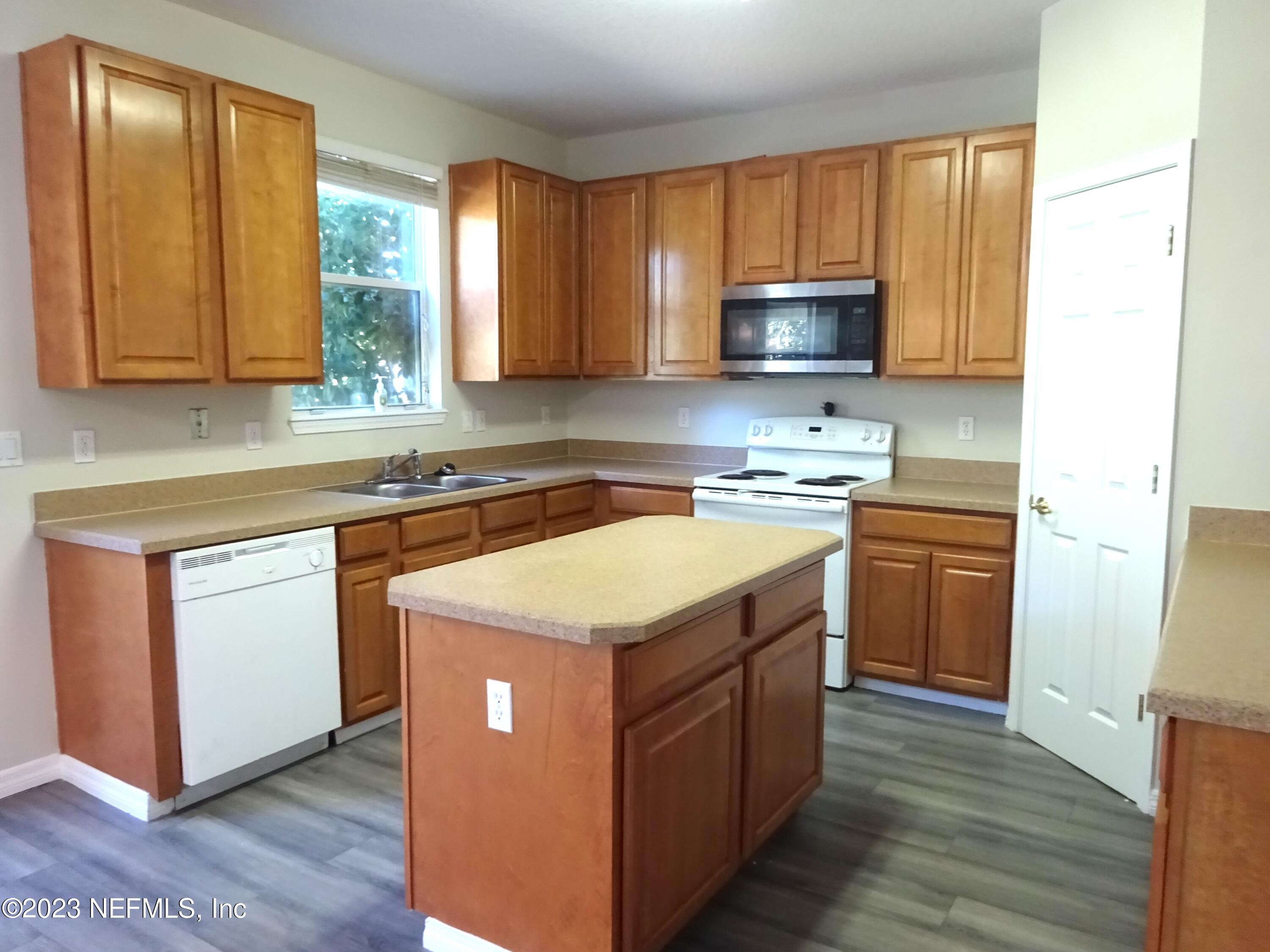 731 East Red House Branch Road St. Augustine, FL 32084 - Photo 10 of 54 a kitchen with stainless steel appliances granite countertop a stove a sink and a microwave