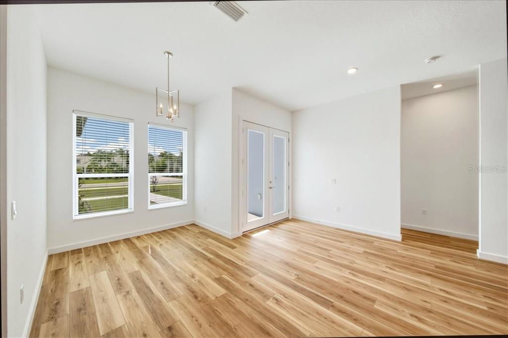 1215 Rio De Janeiro Avenue Punta Gorda, FL 33983 - Photo 11 of 65 a view of an empty room with wooden floor and a window