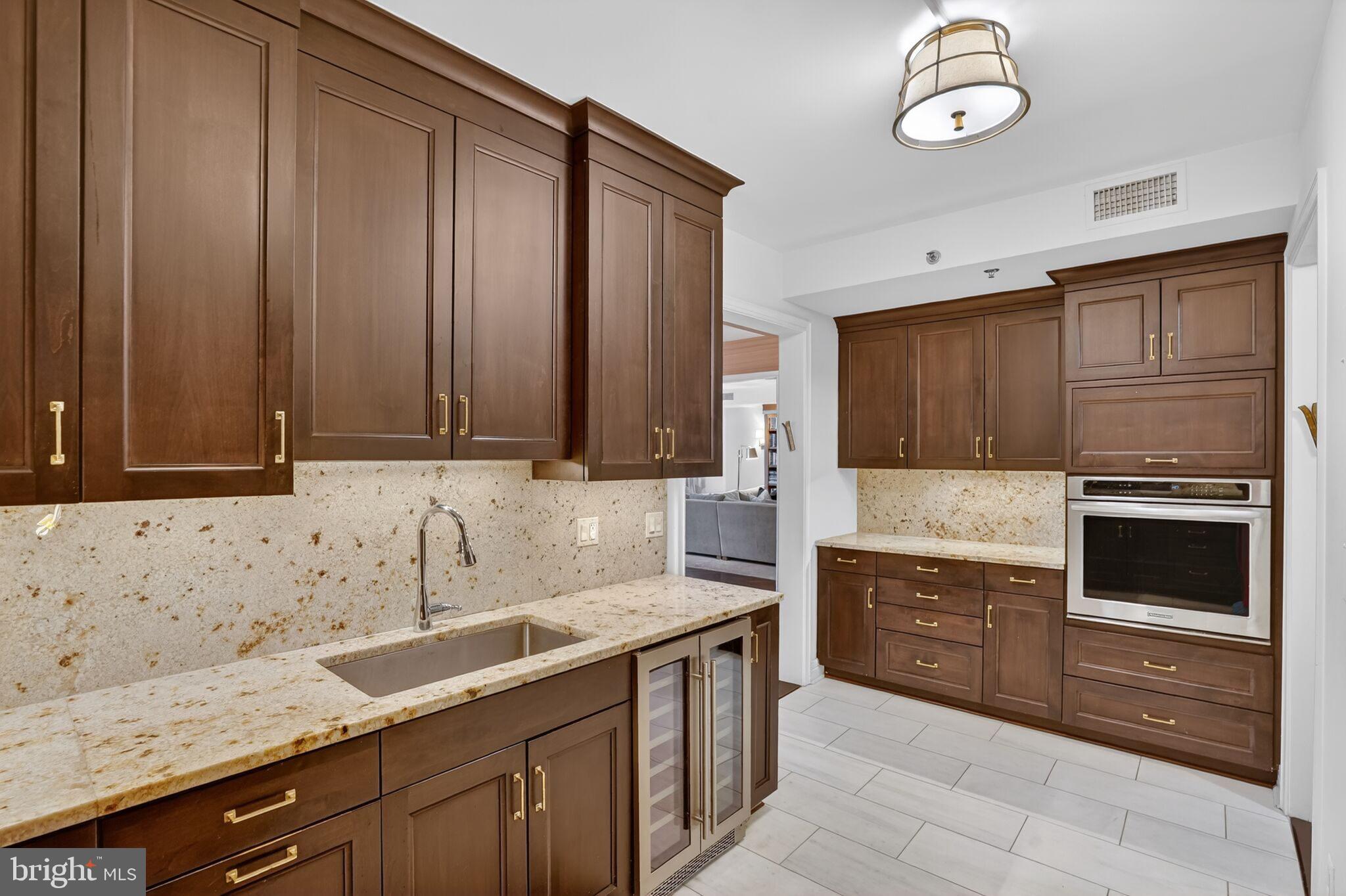 1111 23rd Street Northwest, Unit 2B Washington, DC 20037 - Photo 9 of 22 a kitchen with granite countertop cabinets stainless steel appliances and a sink