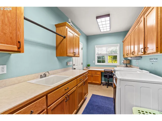 a utility room with cabinets washer and dryer