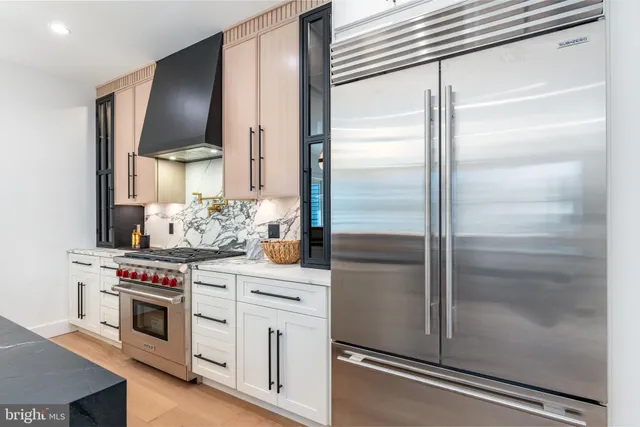 a living room with furniture a potted plant and kitchen view