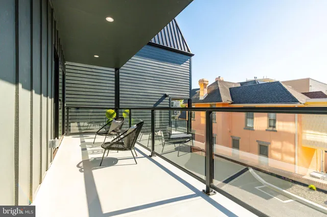 a spacious bedroom with a bed a couch and a large window