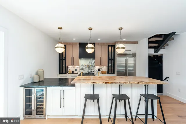 a view of a dining room and livingroom with furniture wooden floor a rug and a chandelier