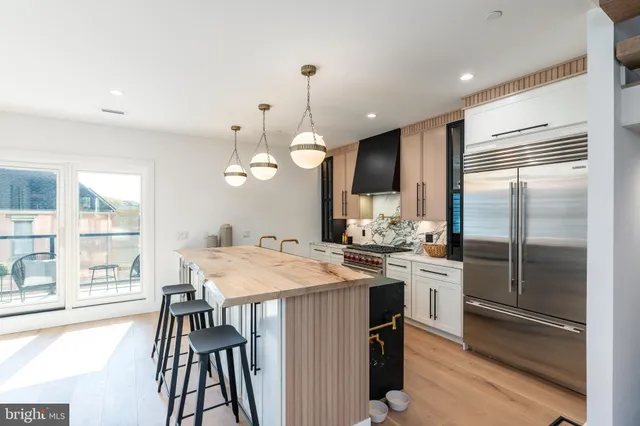 a kitchen with stainless steel appliances granite countertop a sink a stove and a refrigerator