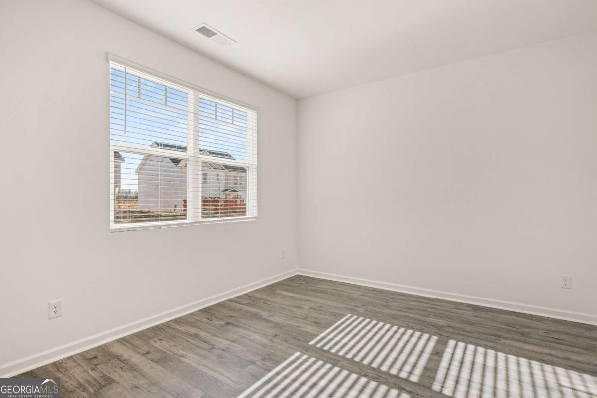 209 Cattle Drive Perry, GA 31069 - Photo 16 of 47 a view of an empty room with wooden floor and a window