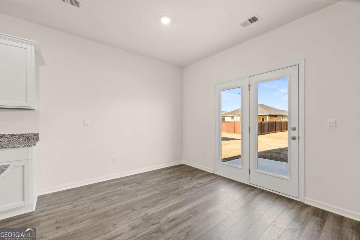 209 Cattle Drive Perry, GA 31069 - Photo 19 of 47 an empty room with wooden floor and sliding door
