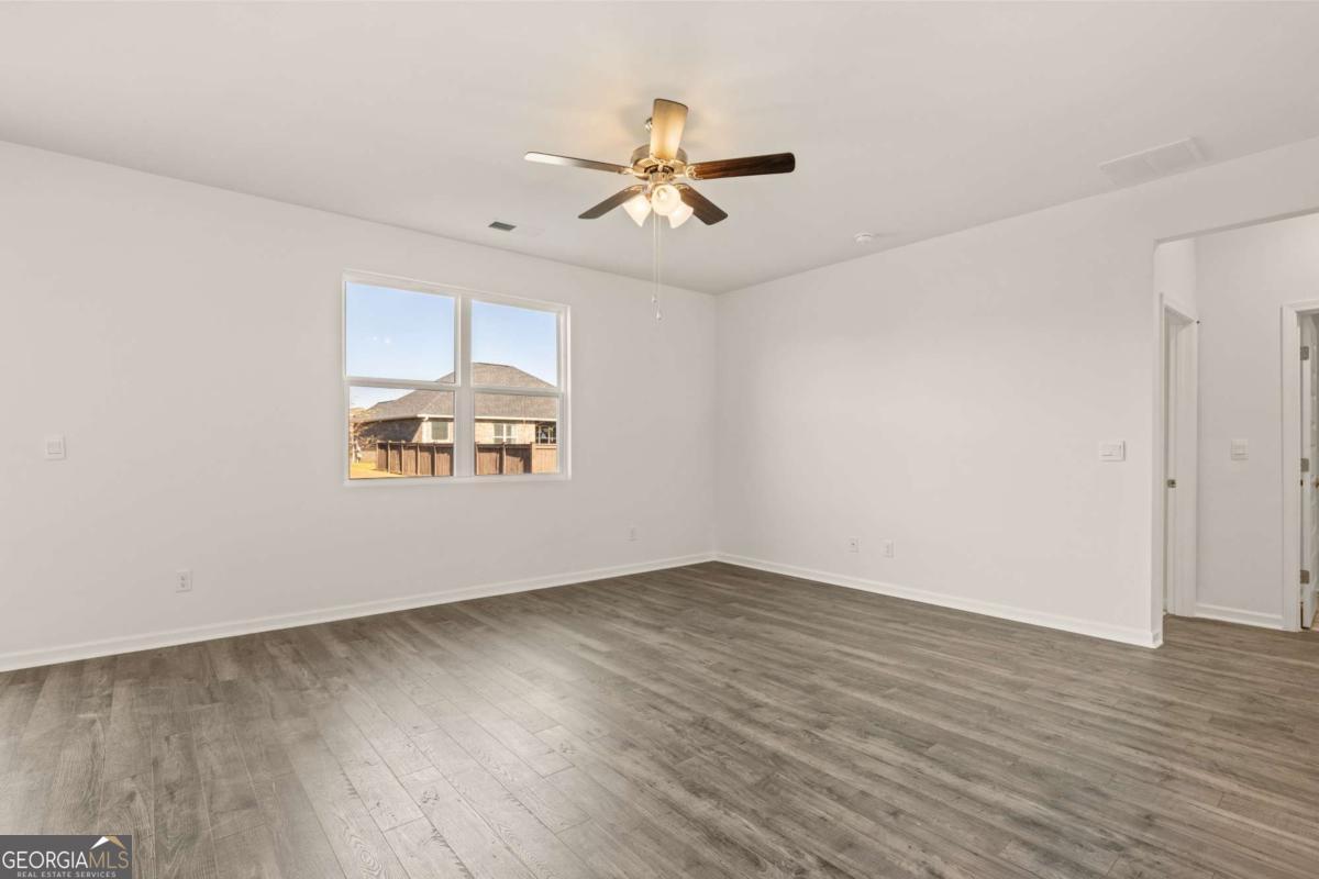 209 Cattle Drive Perry, GA 31069 - Photo 24 of 47 an empty room with wooden floor ceiling fan and windows