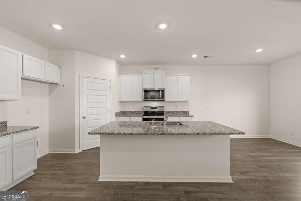 209 Cattle Drive Perry, GA 31069 - Photo 7 of 47 a large kitchen with stainless steel appliances granite countertop a stove a sink and a refrigerator