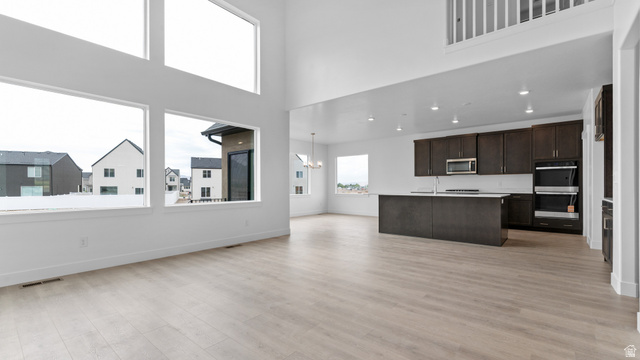 4170 North 560th West, Unit 6 Tooele, UT 84074 - Photo 2 of 20 Spacious open-concept living area featuring vaulted ceilings and extensive window placements
