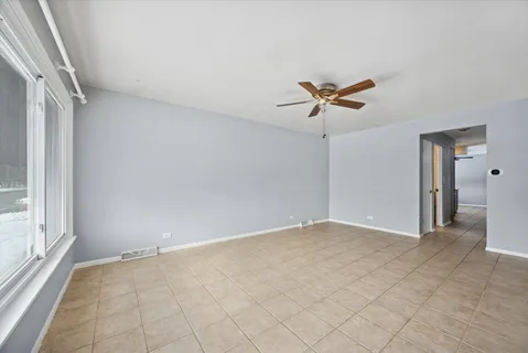 wooden floor in an empty room with a ceiling fan