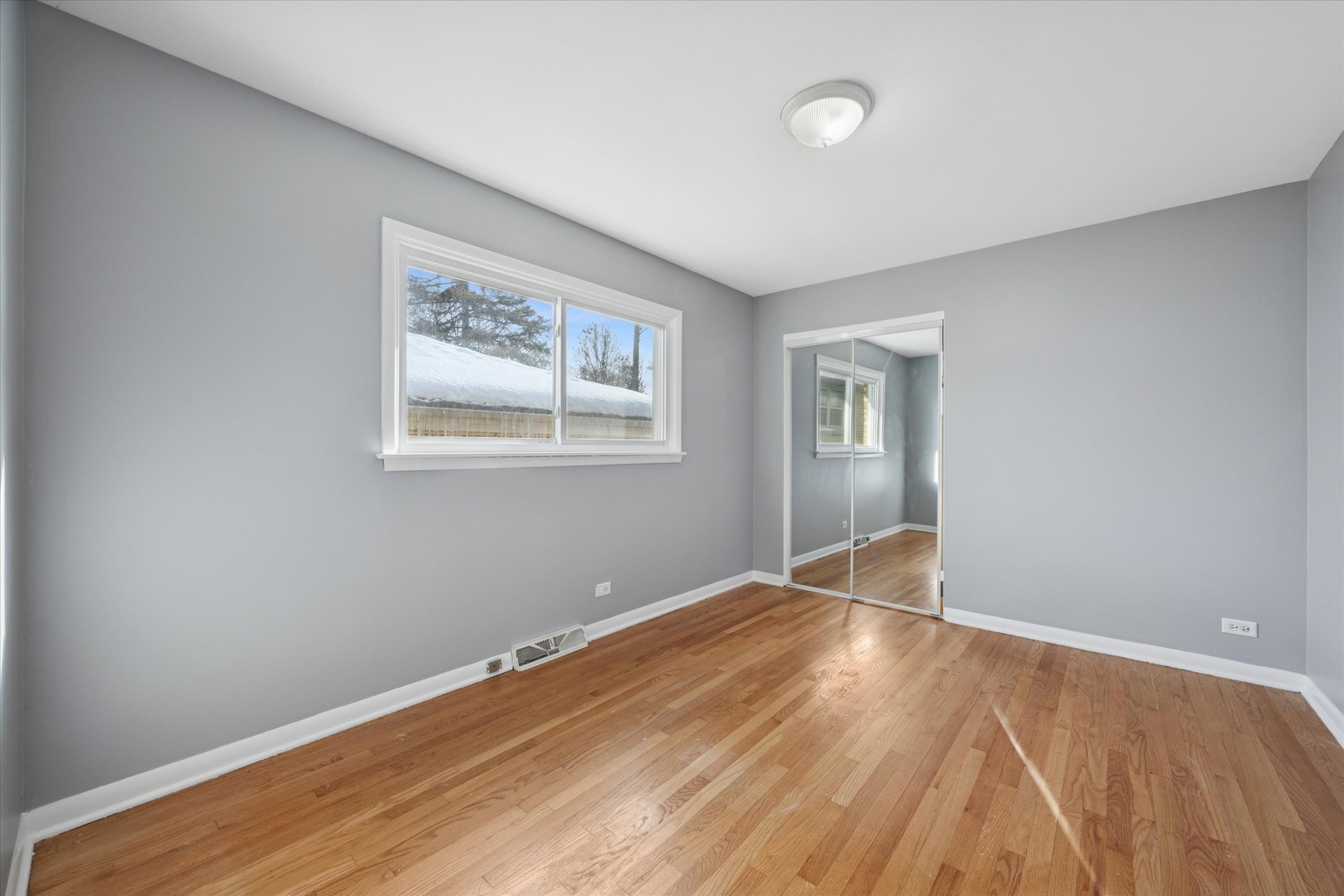 6718 41st Street Stickney, IL 60402 - Photo 5 of 15 a view of an empty room with wooden floor and a window