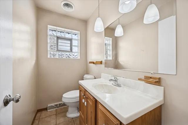 a bathroom with a sink a toilet and a mirror