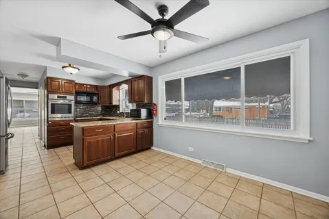 a kitchen with stainless steel appliances kitchen island granite countertop a refrigerator a stove and a sink