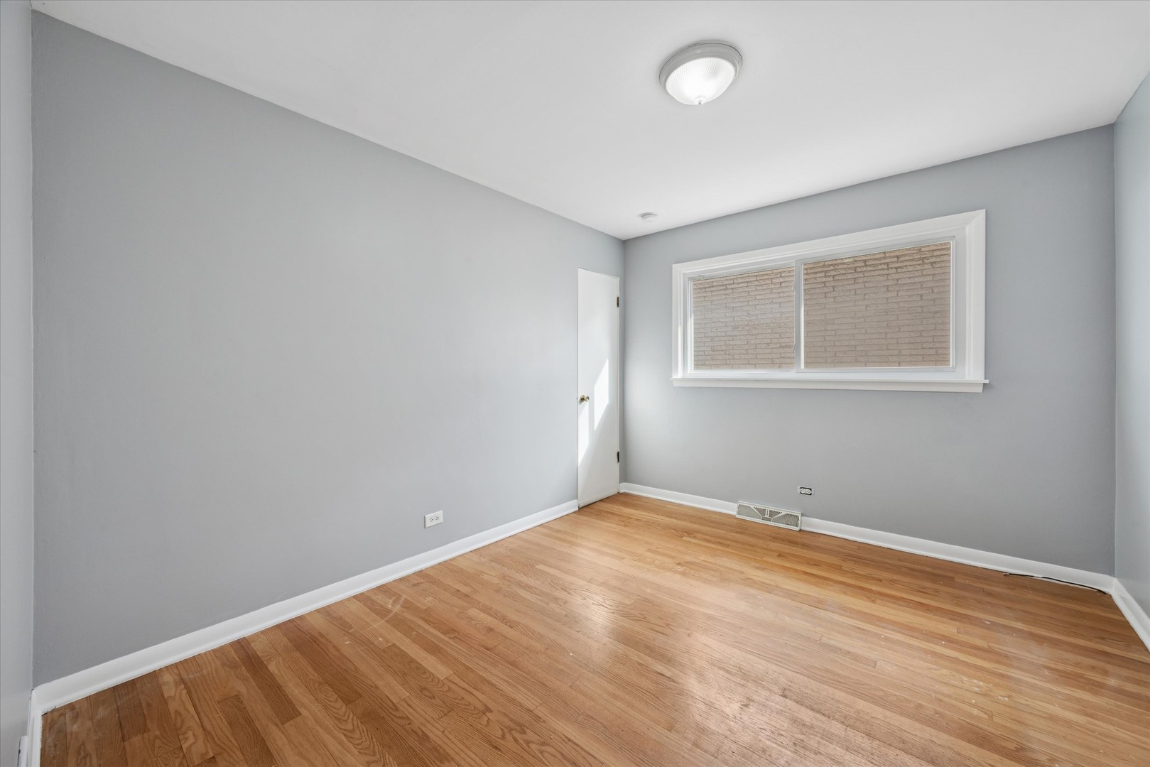 6718 41st Street Stickney, IL 60402 - Photo 10 of 15 a view of an empty room with wooden floor and a window