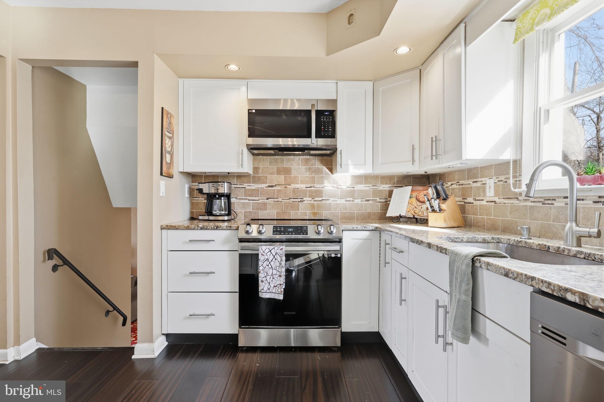 5 Patrick Lane Yardley, PA 19067 - Photo 15 of 51 a kitchen with stainless steel appliances granite countertop a stove top oven a sink dishwasher and a refrigerator with wooden floor