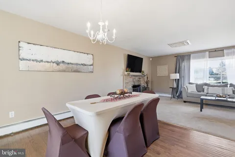 a view of a dining room with furniture a chandelier and wooden floor