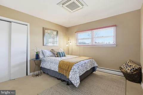 a bed sitting in a bedroom next to a window