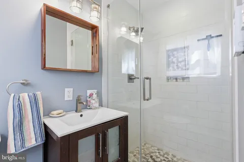 a bathroom with a sink a mirror a vanity and shower