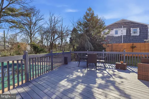 a view of a roof deck with table and chairs with wooden floor and fence