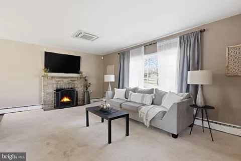 a living room with furniture a fireplace and a flat screen tv