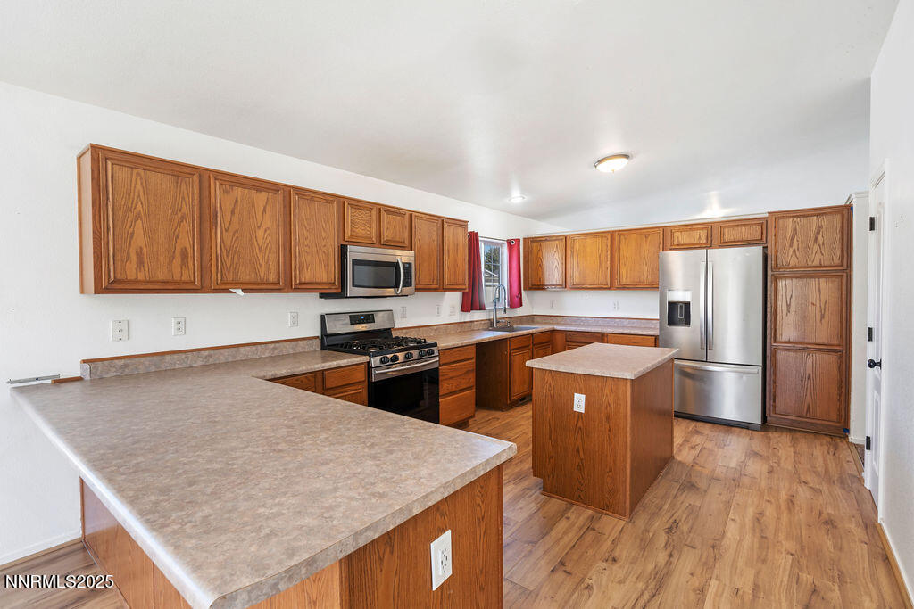 17870 Fairfax Court Reno, NV 89508 - Photo 17 of 23 a kitchen with stainless steel appliances granite countertop a stove a refrigerator a sink dishwasher and wooden cabinets with wooden floor