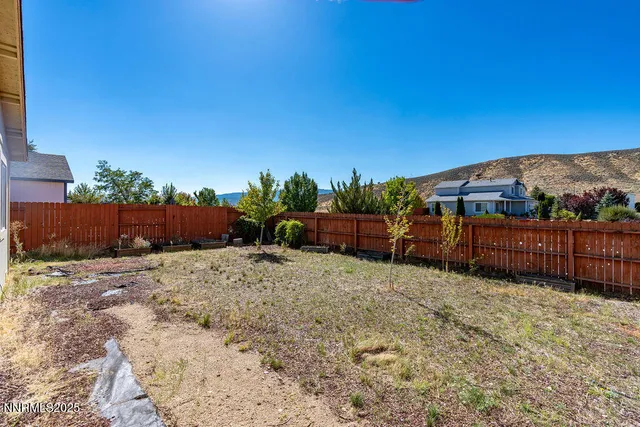 a view of a backyard with wooden fence