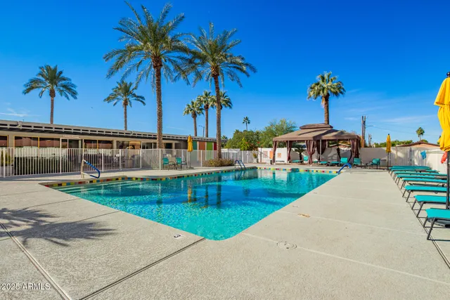 a view of a house with a yard and palm trees