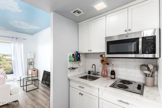 a kitchen with stainless steel appliances white cabinets a stove a sink and a microwave