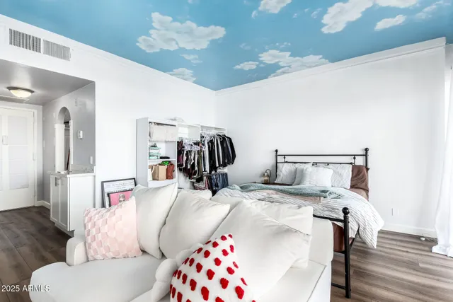 a bedroom with a bed and wooden floor