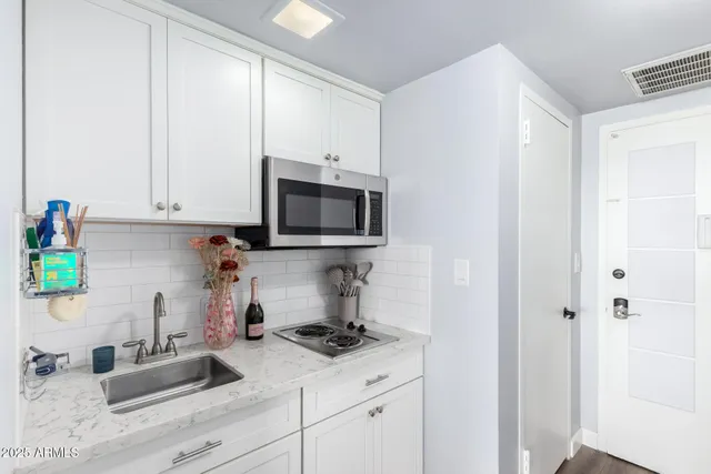 a kitchen with stainless steel appliances granite countertop a sink and a stove top oven