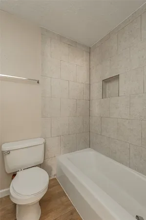 a white toilet and tub sitting next to a bathroom sink