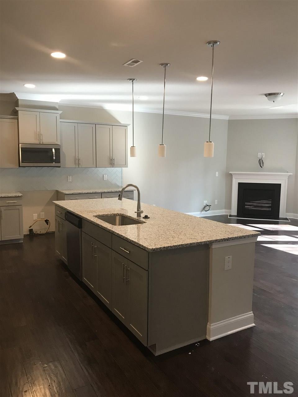 605 Newlyn Drive, Unit 59 Raleigh, NC 27606 - Photo 2 of 6 a kitchen with stainless steel appliances granite countertop a sink a stove and a wooden floors