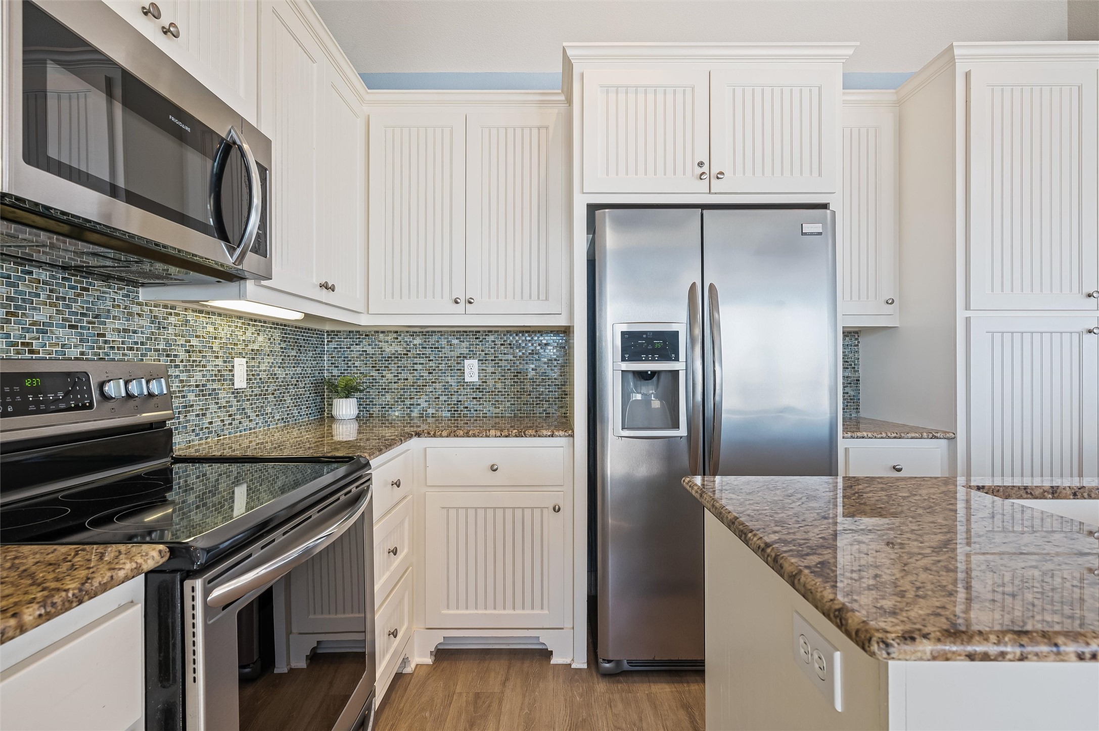 804 Eastview Crystal Beach, TX 77650 - Photo 17 of 50 a kitchen with stainless steel appliances granite countertop a refrigerator a stove and a sink with wooden floor