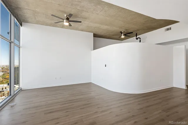 a view of a big room with wooden floor and windows