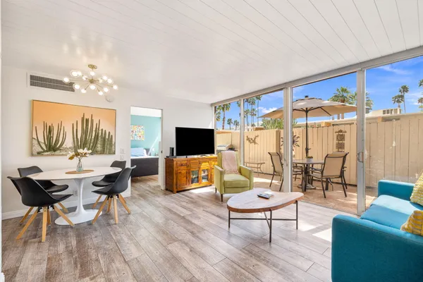 a living room with furniture a flat screen tv and a large window